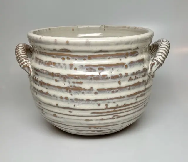 A brown pot poured with white paint
