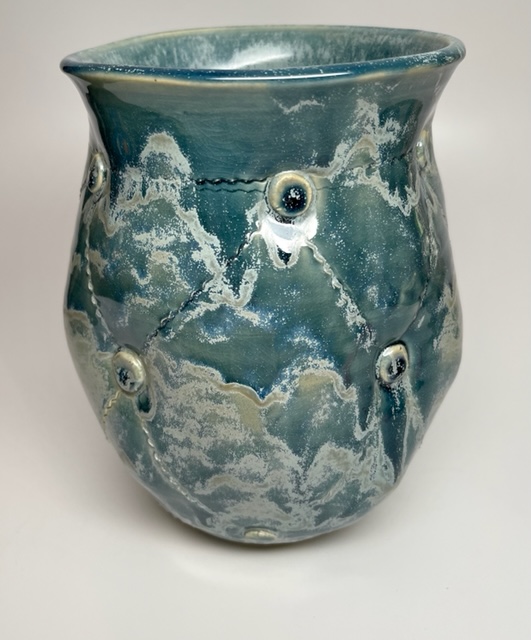 A blue vase with hints of white paint