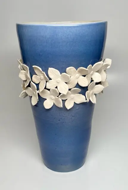 A blue vase with white flowers