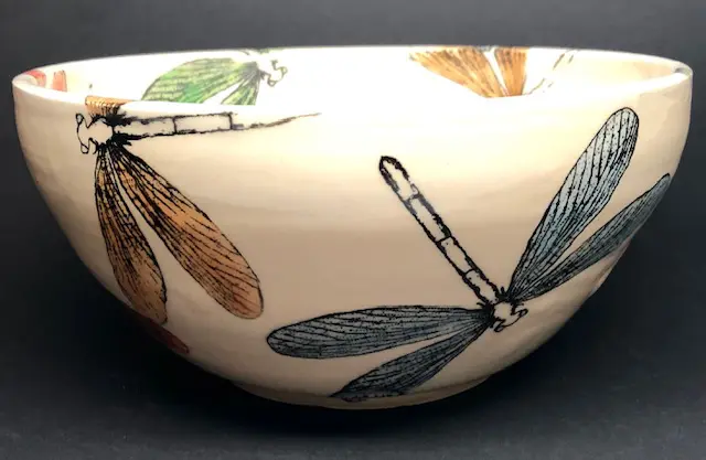 A white bowl with colorful dragonfly design